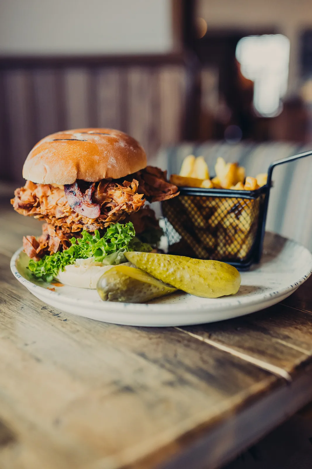 A plate with Buttermilk Chicken Burger, Pickles and Chips