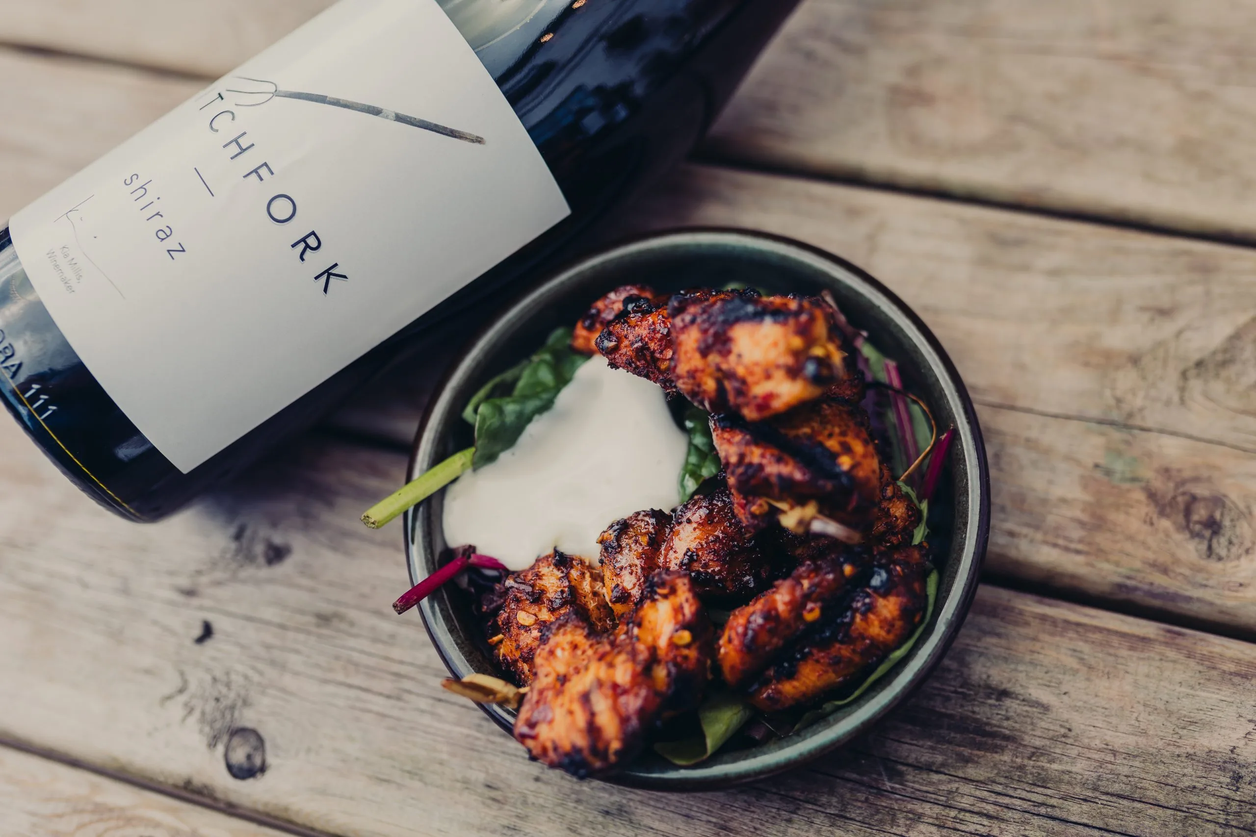 A dish next to a wine bottle that's slightly out of frame