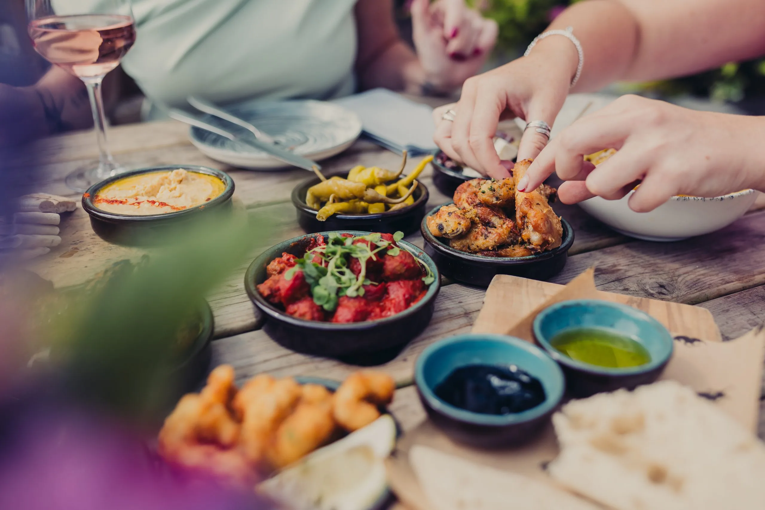 Various people holding items from the various dishes that are on the table